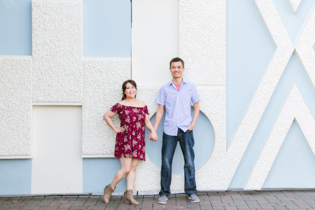 Couple posing for engagement photos in Fantasyland at Disneyland