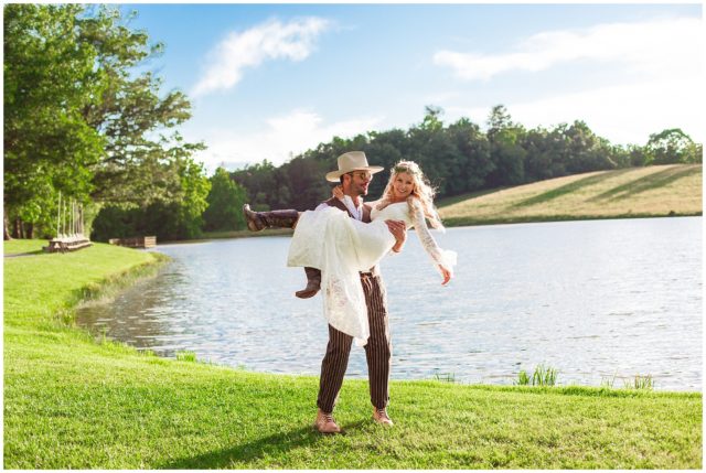 Bride and groom nuzzle in front of lake for bohemian wedding portraits