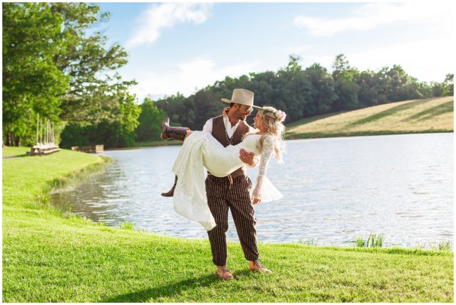 Bride and groom nuzzle in front of lake for bohemian wedding portraits