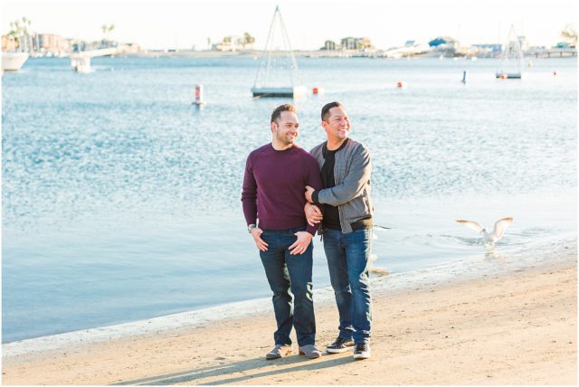 Same sex couple posing on the sand in the marina in Long Beach at sunset.