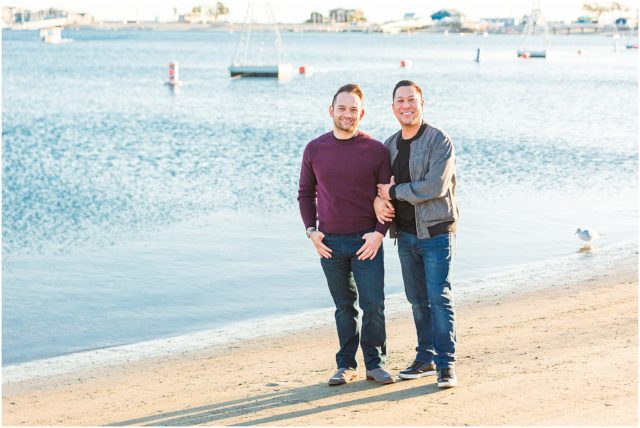 Grooms posing for engagement session on the sand in the marina in Long Beach at sunset.