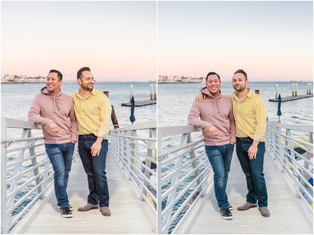 Same sex couple posing on rock cliff overlooking the marina in Long Beach at sunset.