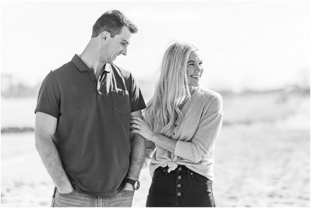 Newly engaged couple posing for their surprise beach engagement session in Santa Monica in the sand