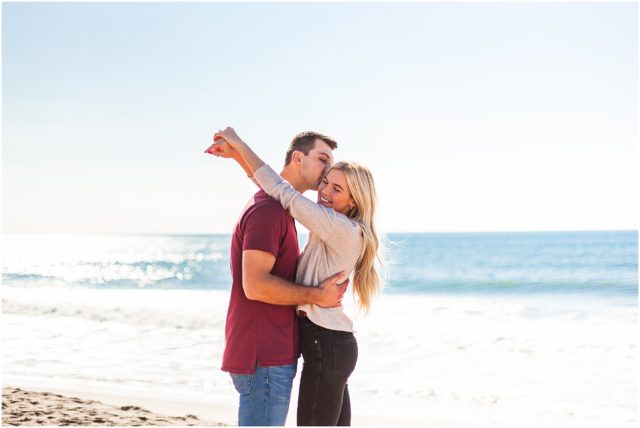 Newly engaged couple embracing on beach