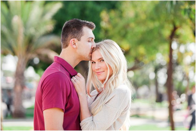 Newly engaged couple posing at their surprise beach engagement session in Santa Monica