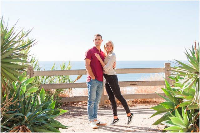 Newly engaged couple posing at their surprise beach engagement session in Santa Monica