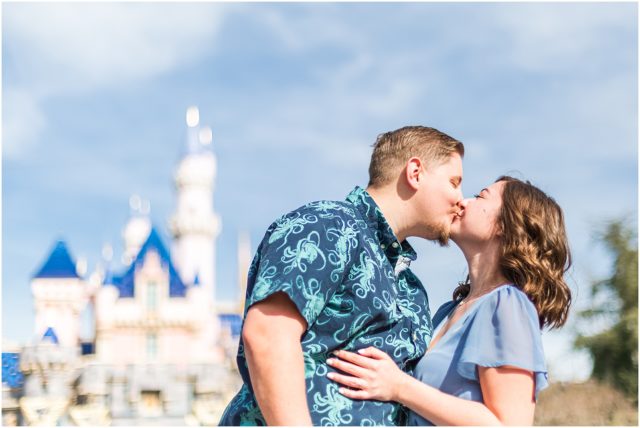 Couple posing for engagement session  in front of CASTLE in Fantasyland at Disneyland Park.