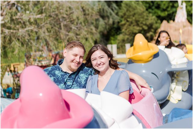Couple posing for engagement session  on Dumbo Ride in Fantasyland at Disneyland Park.