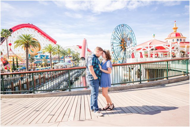 Couple posing for engagement session  on Pixar Pier at Disneyland Park.