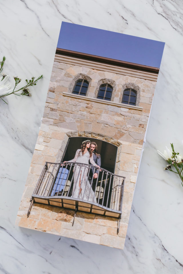 Professional Lay Flat Wedding Album on marble surface, showing a vertical full page spread