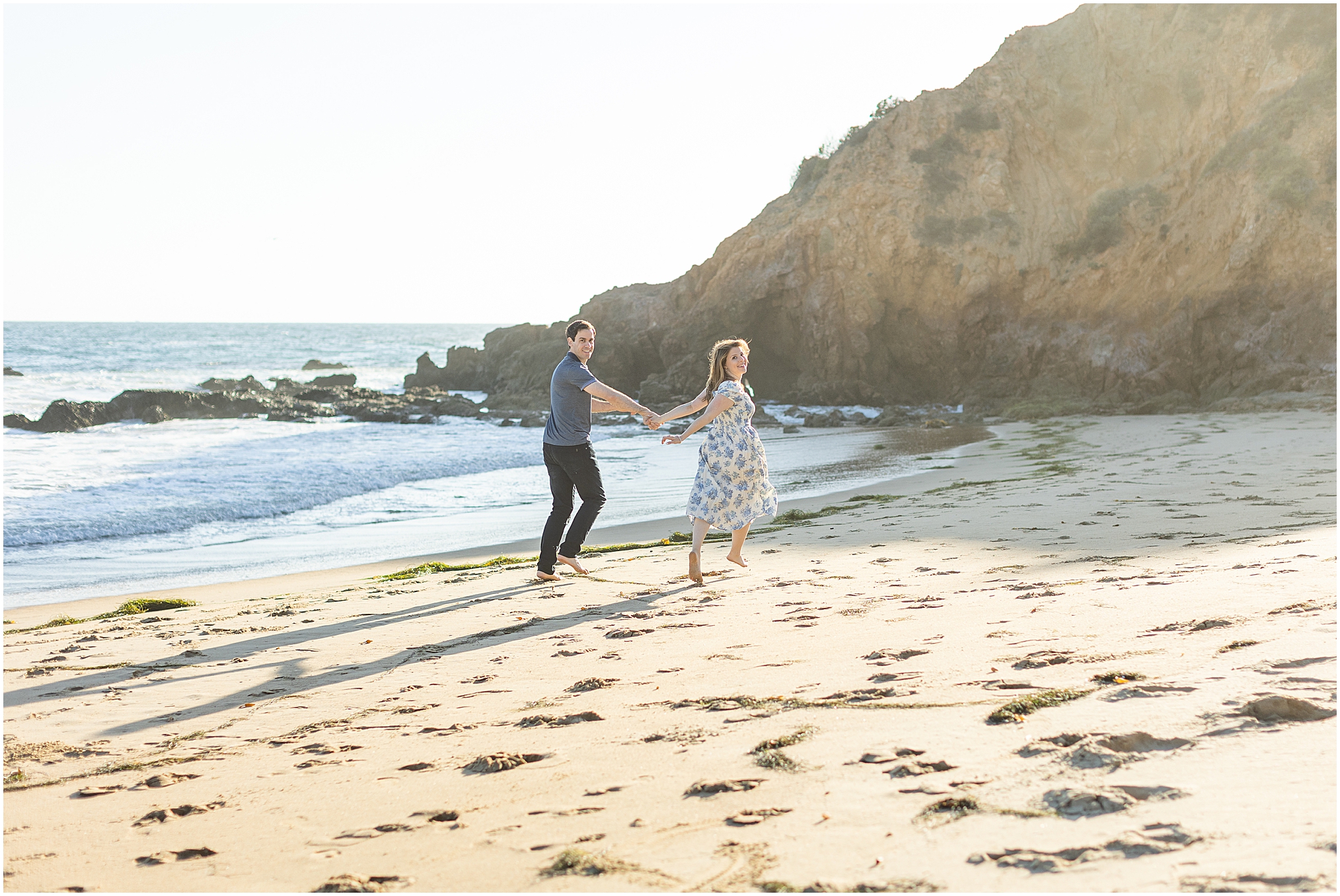 An Irvine Cove Engagement Session in Laguna Beach at golden hour. This lovely couple play on the beach in the golden sunset.
